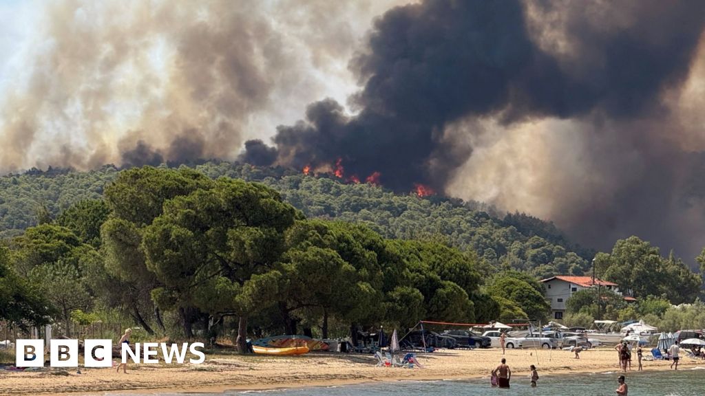 Mersul pe plajă privește incendiile de vegetație din Grecia