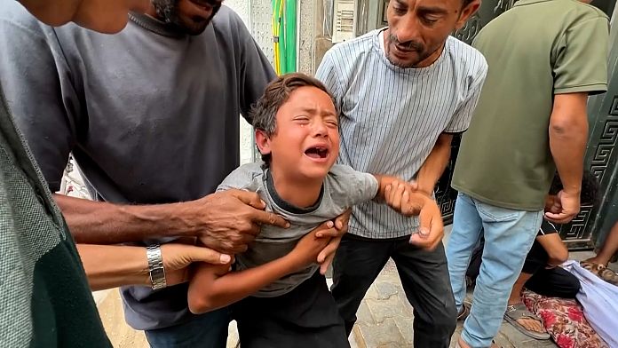 Un băiat îndurerat din Gaza plânge după tatăl său, ucis lângă un centru de ajutor umanitar